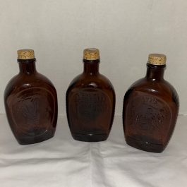 Group Of 3 Amber Embossed Log Cabin Syrup Bottles – Liberty, Indian & Patriotic